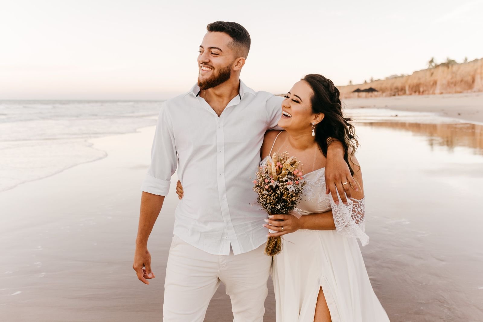 Pareja de recién casados en la playa al atardecer